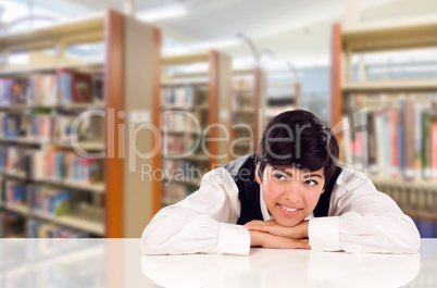 Young Female Mixed Race Student Daydreaming In Library Looking T