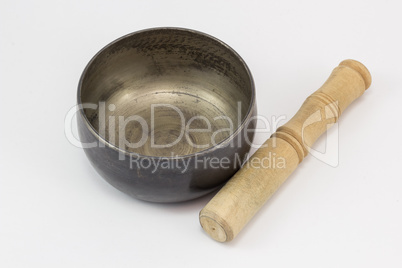 A singing bowl, and a stick besides it.