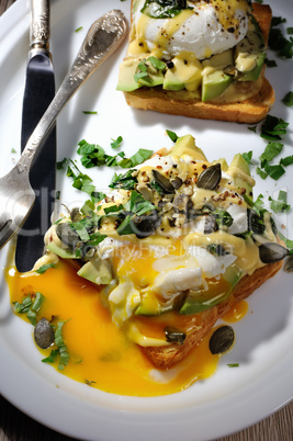Eggs Benedict with avocado on toast
