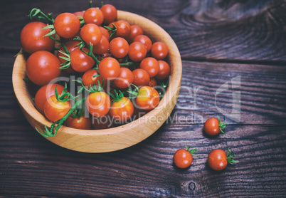 Ripe red cherry tomatoes in a wooden bowl