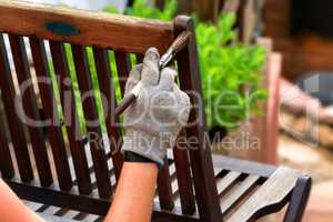 Frauenhand mit Pinsel streicht hölzernes Mobiliar
