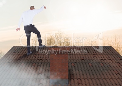 Businessman standing on Roof with chimney and trees in evening light