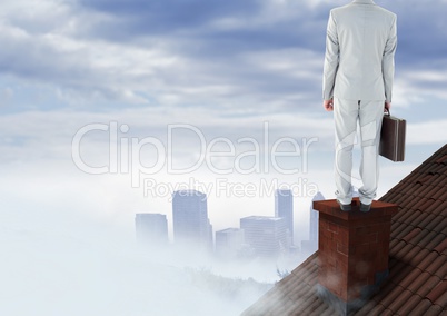 Businessman on roof chimney with city in distance