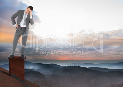 Businessman standing on Roof with chimney and misty colorful sky landscape