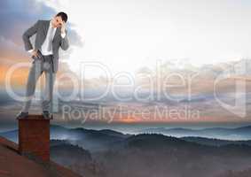 Businessman standing on Roof with chimney and misty colorful sky landscape