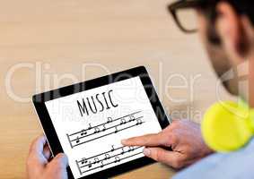 Music notes on tablet screen with mans hands and earphones
