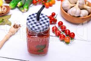 juice from a ripe red tomato in a glass jar