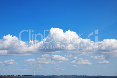 A view of the sea with windmills in the distance