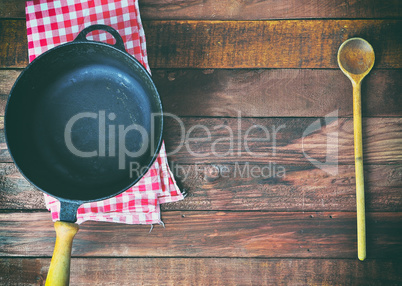 empty black cast-iron frying pan and wooden spoon
