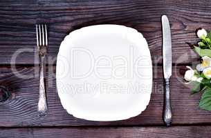 white plate with an iron fork and knife