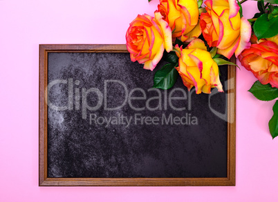 empty black frame and a bouquet of yellow roses