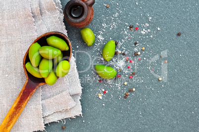 Green olives in a wooden spoon