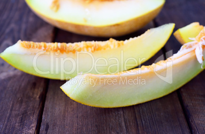 Pieces of ripe melon on a brown wooden table