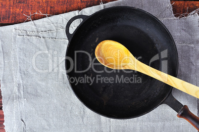empty frying pan with a wooden spoon