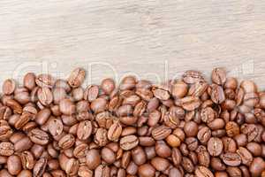 Coffee beans on the brown wooden background.