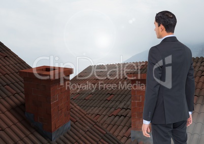 Businessman standing on Roofs with chimney and fog
