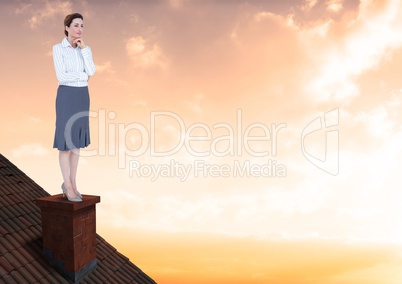 Businesswoman on roof chimney with golden sky