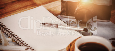 Close up of coffee cup with camera and diary mapp