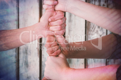 Composite image of cropped image of people stacking fists