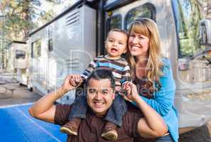 Happy Young Mixed Race Family In Front of Their Beautiful RV At