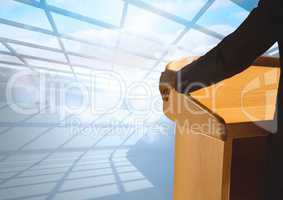 Businessman on podium speaking at conference with windows