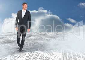 Businessman in sea of documents under sky clouds