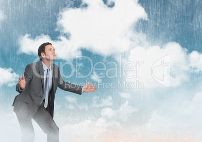 Businessman  reaching out hands in cloudy sky