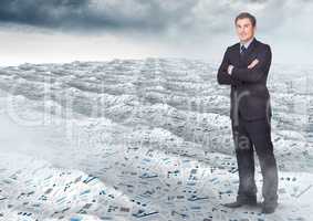 Businessman folding arms in sea of documents under sky clouds