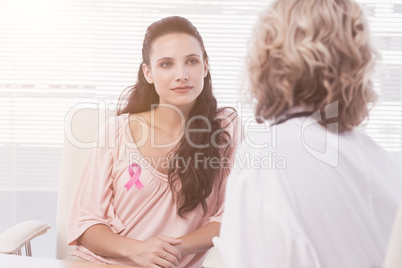 Composite image of female patient listening to doctor with concentration in medical office
