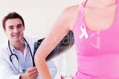 Composite image of mid section of woman wearing ribbon for breast cancer awareness