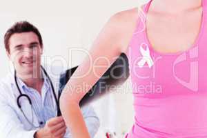 Composite image of mid section of woman wearing ribbon for breast cancer awareness