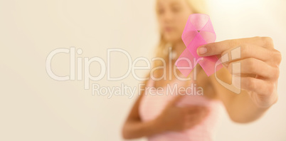 Close-up of woman holding pink ribbon