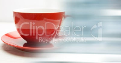 Red coffee cup with blurry blue transition