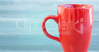 Red cup against blurry blue wood panel