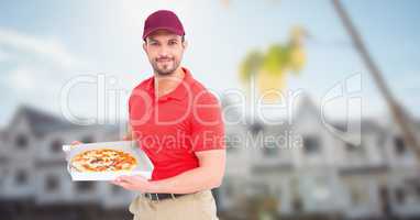 Delivery man with pizza against blurry housing estate