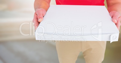 Delivery man lower body with pizza against blurry background