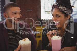 Friends enjoying milkshakes in cafe