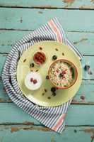 Plate of breakfast cereal with fruits and yogurt on wooden table