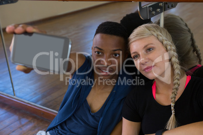 Dancer with female friend taking selfie in studio