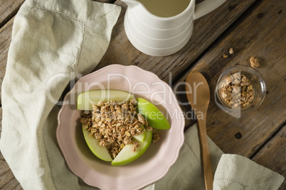 Plate of breakfast cereals with fruits on wooden table