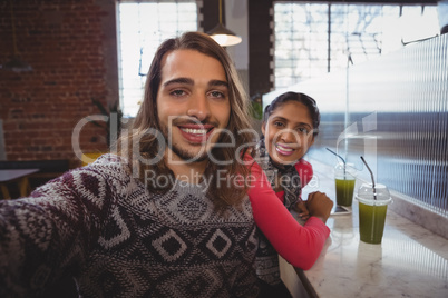 Portrait of happy man with friend in cafe