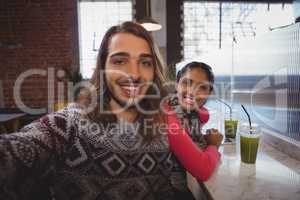 Portrait of happy man with friend in cafe