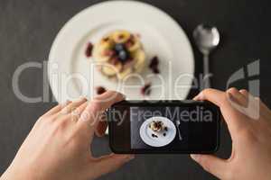 Hands taking photo of breakfast with mobile phone