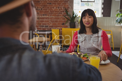 Young woman looking at man in cafe