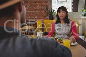 Young woman looking at man in cafe