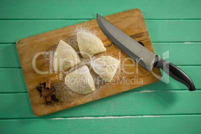Overhead view of raw cookies by knife on cutting board