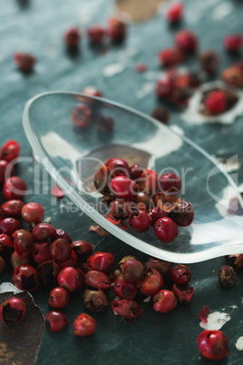 Pink peppercorn and spoon on wooden table