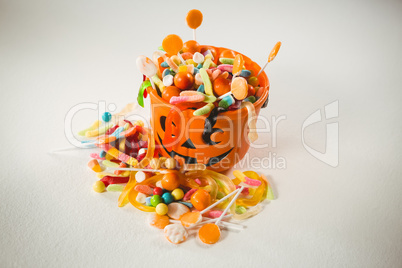 View of orange bucket with various sweet food during Halloween