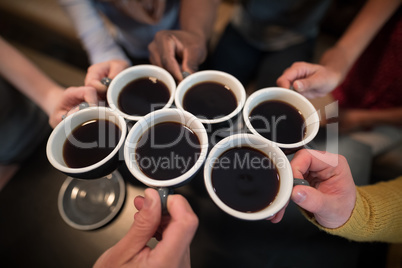 Mid section of friends toasting coffee