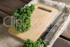 Kale on cutting board with knife at table